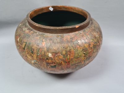 un vase avec un tableau posé sur une table
