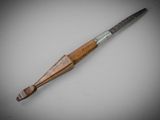 a close up of a knife with a wooden handle on a white surface