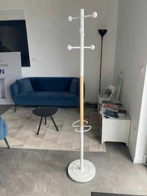 a living room with a blue couch and a white coat rack