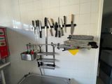 many knives hanging on the wall in the kitchen