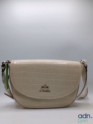 the small white purse is sitting on a white surface