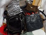 de nombreux sacs et sacs à main dans un panier posé par terre