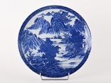 assiette bleue et blanche ornée d'un paysage de montagne