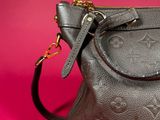 a close up of a louis vuitton handbag on a pink background