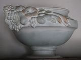 a white vase with a bunch of grapes on it