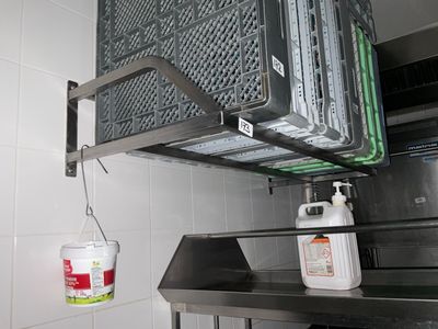 une photo d'une cuisine avec une étagère en métal et un panier en métal