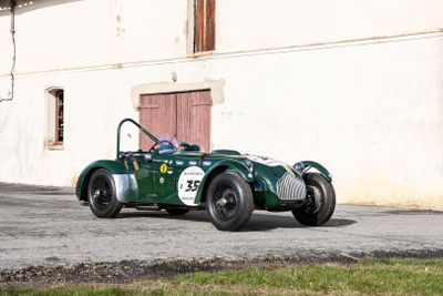 a green car that is parked in front of a building
