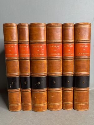 six vieux livres sont alignés sur une table