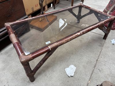 une table basse avec un plateau en verre posée sur un trottoir