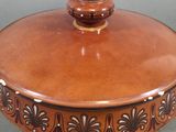 a brown pot with a lid sitting on a table
