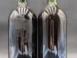 two bottles of wine sitting next to each other on a table