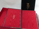 une boîte rouge avec un couvercle noir et une boîte rouge sur laquelle figure une inscription en chinois