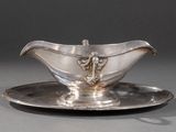 une assiette en argent sur laquelle repose une soucoupe en argent