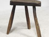 an old wooden stool with two wooden legs on a white surface
