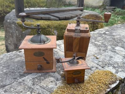 two old coffee grinders sitting on a rock
