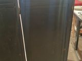 two black cabinets are sitting on top of each other in a room
