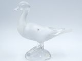 un canard en verre posé sur un socle