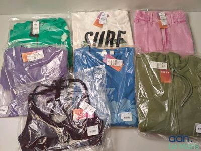 many different colored shirts in plastic bags on a table