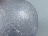 a glass vase with frost on it sitting on a table
