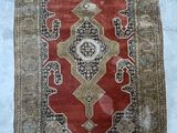 a close up of a rug on a bed with a white sheet