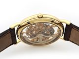a close up of a watch on a white surface