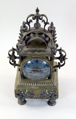 une horloge posée sur un support sur une surface blanche