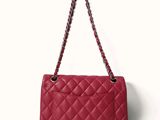 a close up of a red handbag on a white background