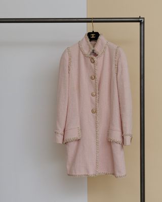 un manteau rose accroché à un porte-vêtements dans une pièce