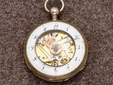 un gros plan d'une montre de poche posée sur un tissu