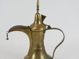 an old brass coffee pot with a handle on a white background