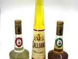 three bottles of alcohol are lined up on a white surface