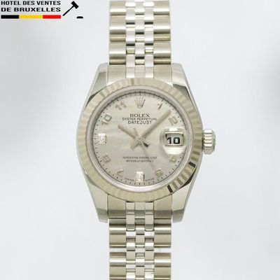 une photo d'une montre Rolex à cadran blanc montée sur un bracelet