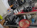 a counter with a lot of bottles and cups on it