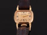 a close up of a gold wrist watch with roman numerals