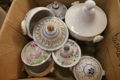 une boîte en carton remplie de nombreuses pièces de poterie de toutes sortes