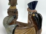a figurine of a woman sitting on top of a bird