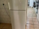un réfrigérateur blanc dans une cuisine au sol carrelé