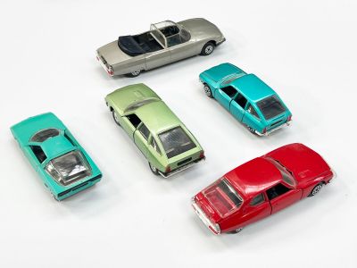 plusieurs petites voitures sont alignées sur une surface blanche