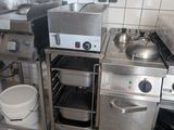 a small kitchen with a stove, sink, and other appliances
