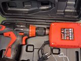 an orange drill and a black and white corded drill in a case