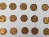 a close up of a bunch of gold coins on a white surface
