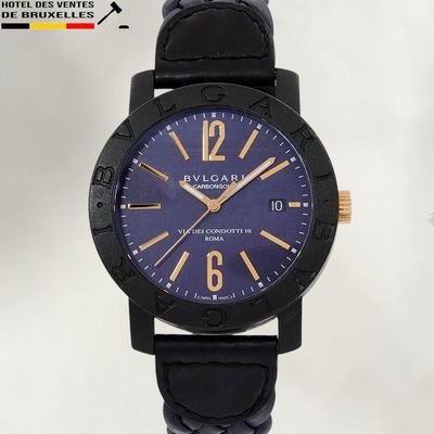 La montre est noire et dorée, avec un cadran bleu.