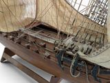 a wooden model of a boat with sails on a stand