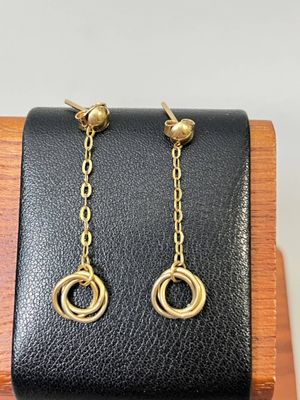 un gros plan sur une paire de boucles d'oreilles posées sur un support en bois