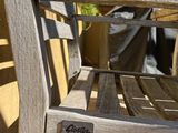 a wooden bench that has a sign on the back of it