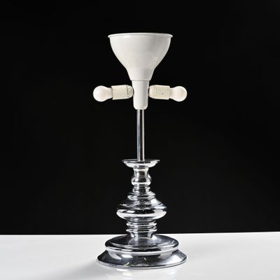 un bougeoir en verre surmonté d'une bougie blanche