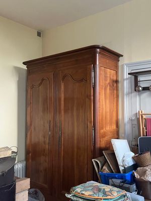 une photo d'un salon encombré avec une grande armoire