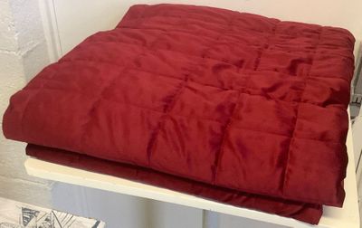 une couverture rouge posée sur une table blanche
