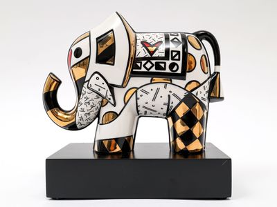 statue d'un éléphant avec une horloge sur la tête, posée sur un socle