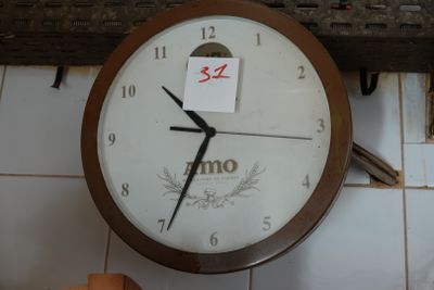 a clock that is hanging on the wall with a note attached to it